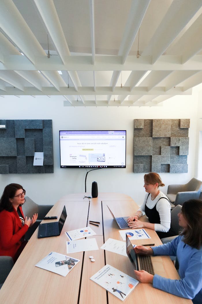 creative-01 Women collaborating in a modern office, engaging in teamwork and technology discussions.